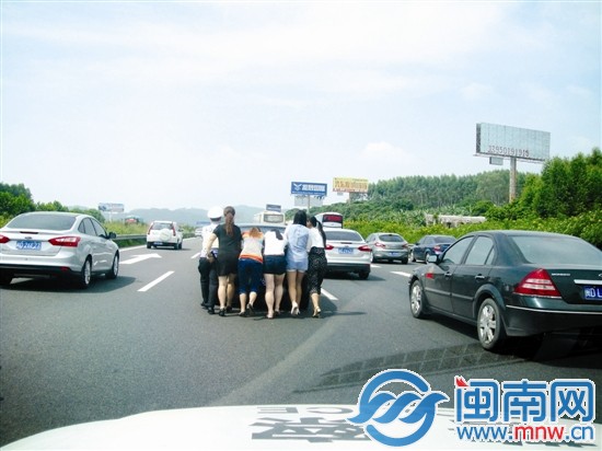 警民合力将故障小车推至紧急停车带