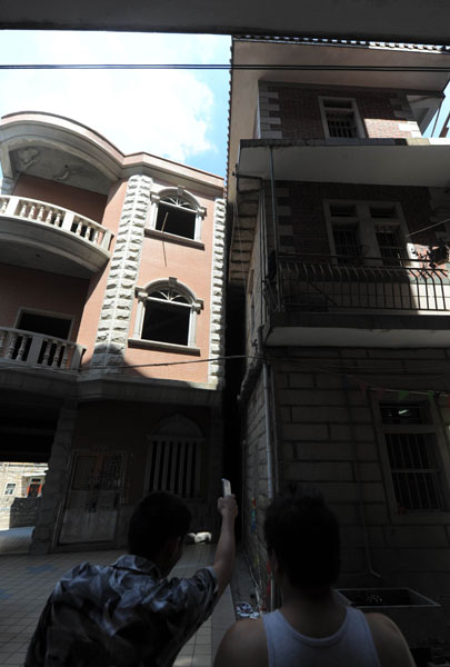 右边苏宣启家，倾斜后靠在左边的混凝土结构民房，原 