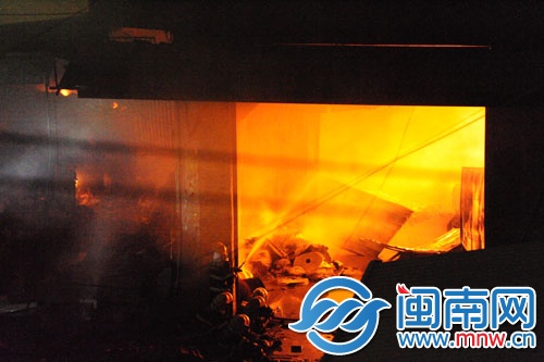 仓库火势很旺，消防员用水枪压制