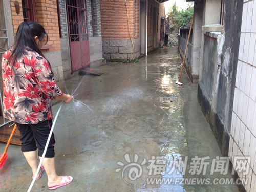 村民在冲洗自家门口的泥沙