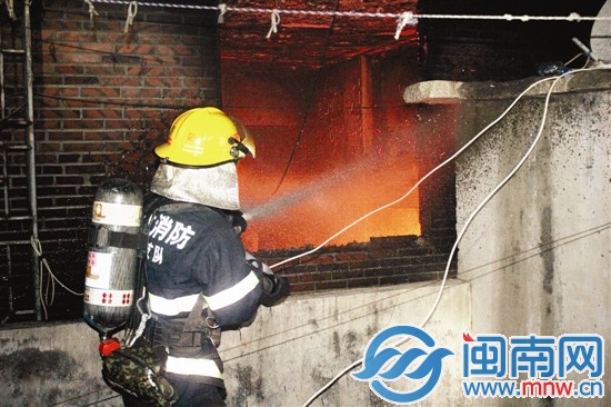 消防官兵朝着火房间内喷水