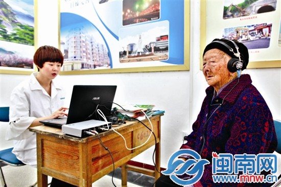 96岁的张阿婆戴上耳机测试听力