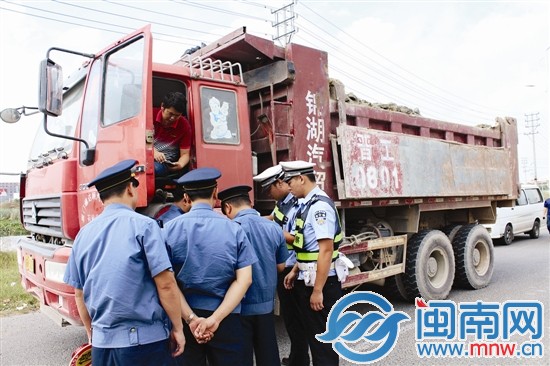 证件不齐的工程车正接受执法人员的检查