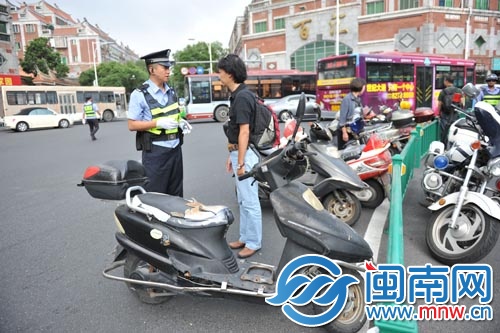 民警在泉州市区涂门街百源路路口查处超标电动车交通 