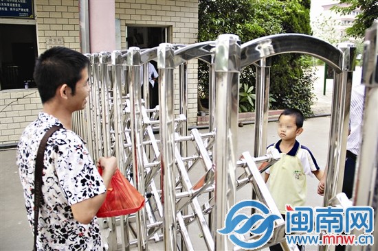 父亲只能隔着学校的铁门看望儿子
