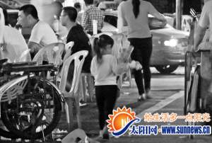 卖花的小孩穿梭于排档之间。记者 常海军 摄