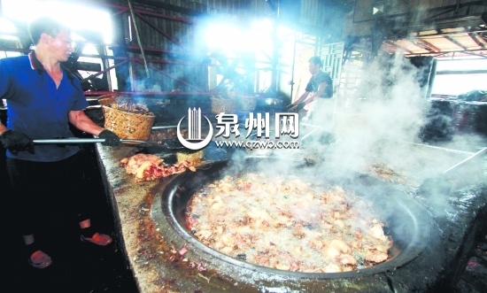 两名工人围着四口大锅炼猪油，现场散发出阵阵恶臭。