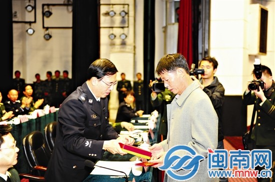 公安部政治部主任夏崇源向陈洲贵的父亲颁发证书