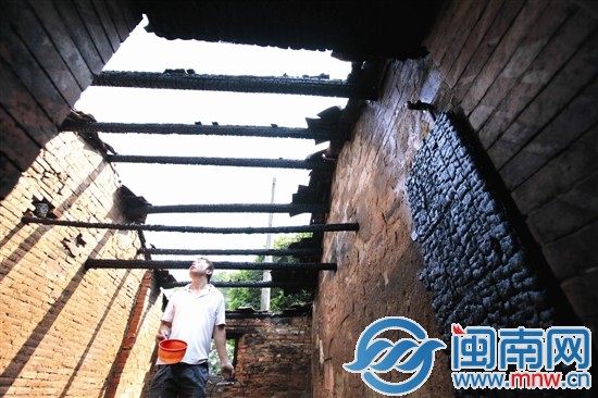 屋顶都烧毁了，屋主拿水寻找小火苗