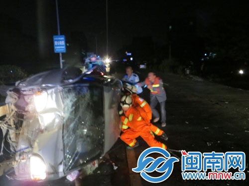 消防正在对被压在车底的司机进行施救