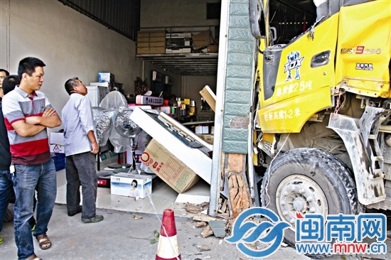 土方车冲向五金店，店门口的柱子被撞得砖块脱落