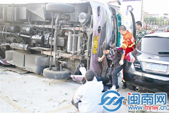 乘客冯阿姨被消防官兵搀扶出侧翻中巴后，惊魂未定