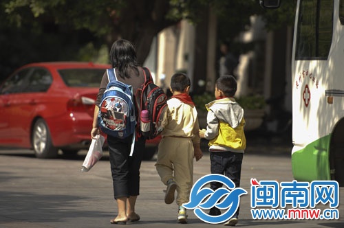 一名女士一肩一个书包