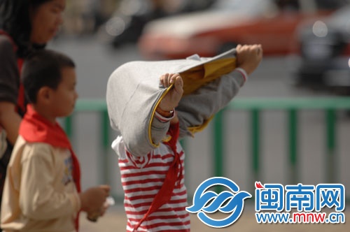 太阳太大，孩子将衣服反转挡太阳