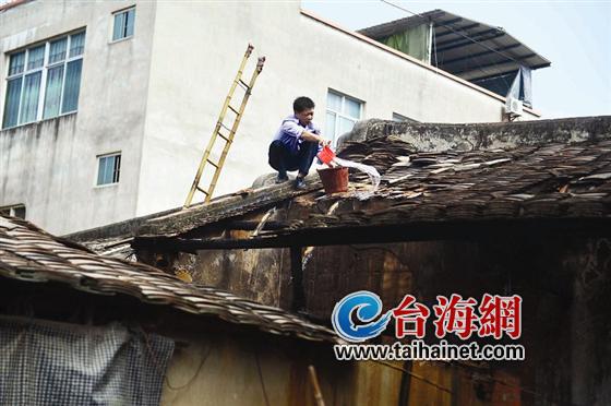 民警在房顶浇灭阴燃的火苗