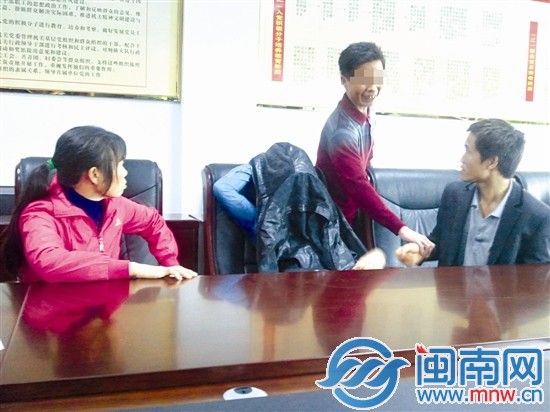为避免当众流泪难堪，小江用外套盖住自己的头