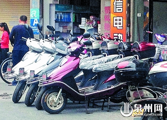 市区东街一电动车店，门口摆放着一排全新的超标电动 