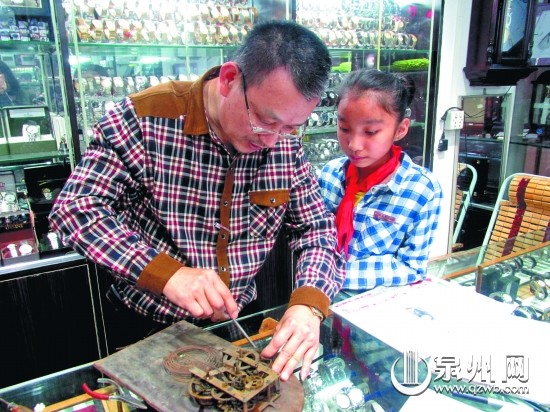 陈金龙修钟时，孙女常站身旁观看