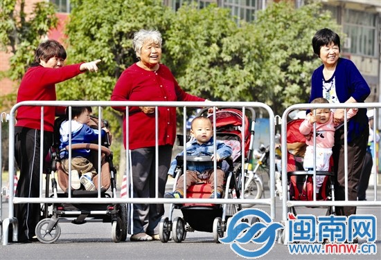 3位阿婆带着小宝贝们在路边观赛