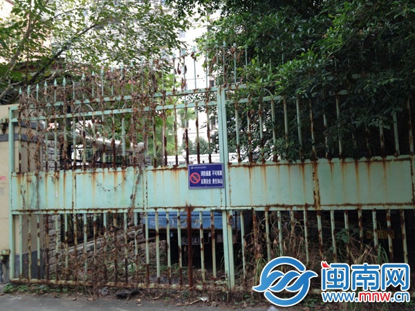 消防通道门外就是市政放置的废弃车辆；大门锈迹斑斑 