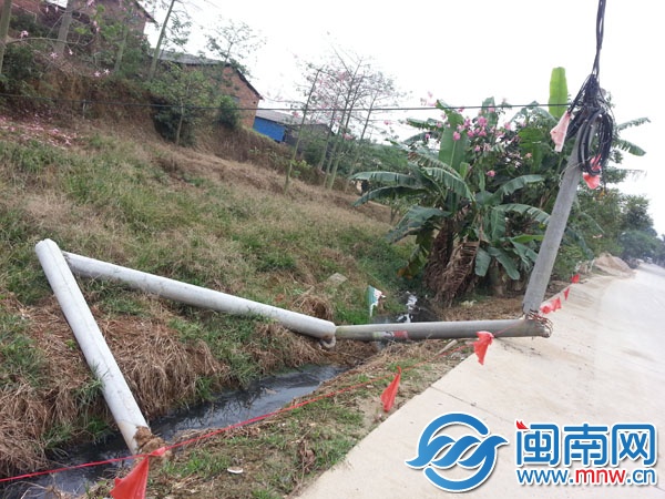 电线杆折断后一半悬空（近处是另一根废弃的电线杆）