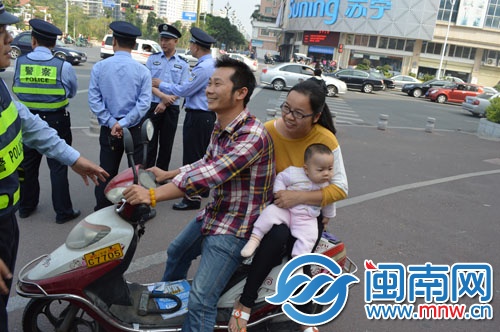 这辆车后座乘客怀抱婴儿，属超载