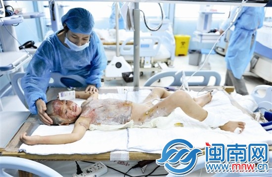 母亲在重症监护病房内照顾女儿