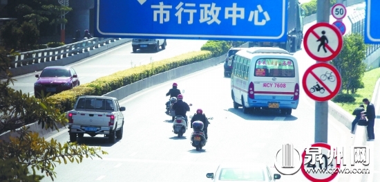 几辆电动车和摩托车无视入口处的禁令标志