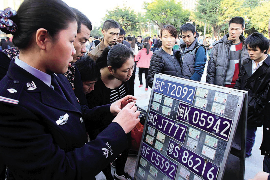 活动现场民警在教市民如何识别假牌、假证