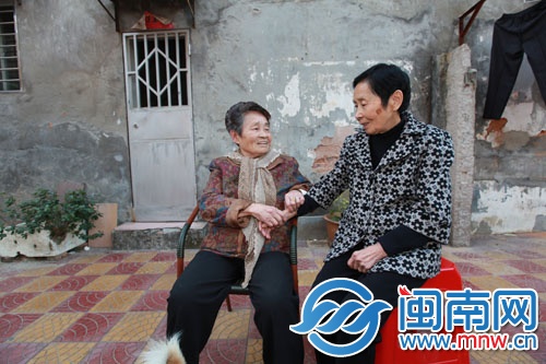 阮阿婆（左）在家门口免费为厝边看病