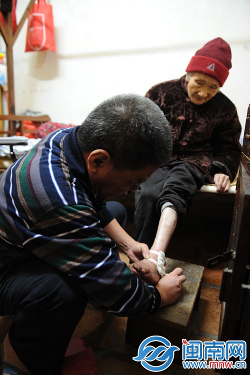 老林为母亲李阿婆包扎伤口