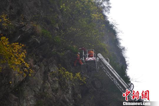 　图为消防官兵在半山腰救援男子遗体