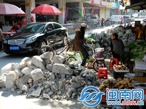 大量石块堆在路边，道路只能容一辆小车通过