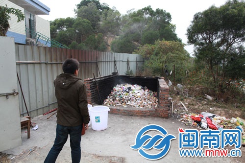 这个垃圾堆放场地内冒着烟，飘出呛人气味