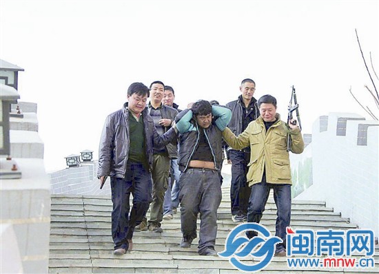 一番枪战后，悍匪（双手抱头者）终于落网