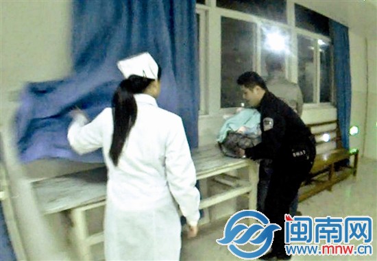 民警抱着她，她裹着厚厚的棉被，呼吸微弱