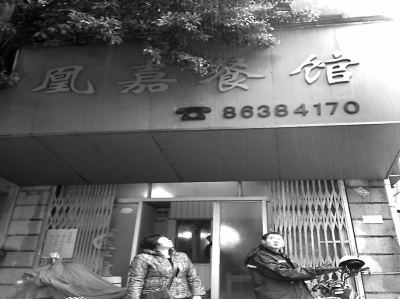 洪凤媚站在自家店门口，看着“凰嘉餐馆”4个字黯然 