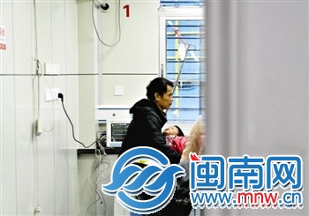 病房内，一位亲戚抱着3岁的小丽，呆望着