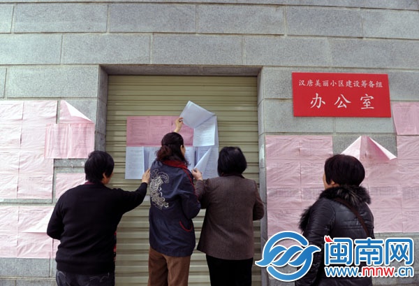汉唐天下小区业主翻看新贴出来的公告