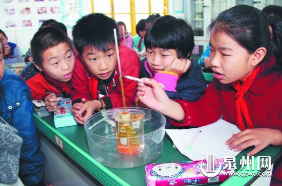 古县小学六年级学生在科学室开展“液体的热胀冷缩” 