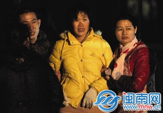 失踪者老张的妻子（中间）在厂房外焦急等待