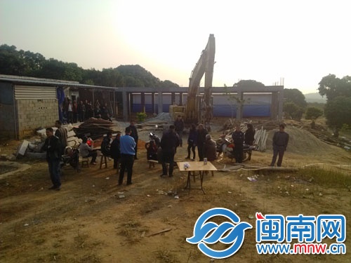 挖掘机还停在现场，后方就是违建的房子
