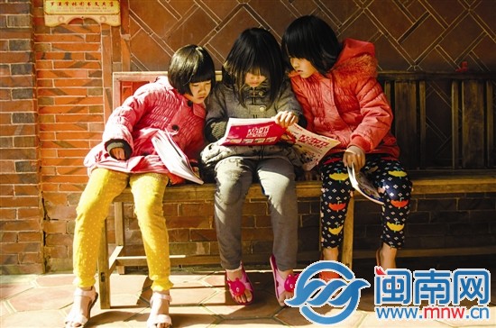 留守儿童收到捐赠的书籍迫不及待地看起来