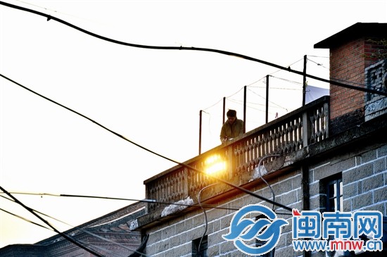 2014年1月7日，一年轻人沐着晨光为西街写生