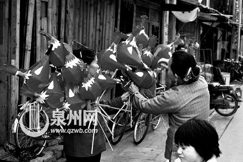 一位老人在挑选公鸡灯