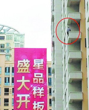 该男子爬上高楼，半身悬空，十分危险