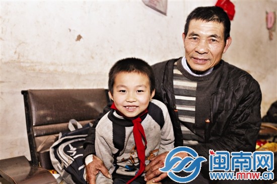 以前没跟家人合影，当记者给他拍合照时，小文杰乐开 