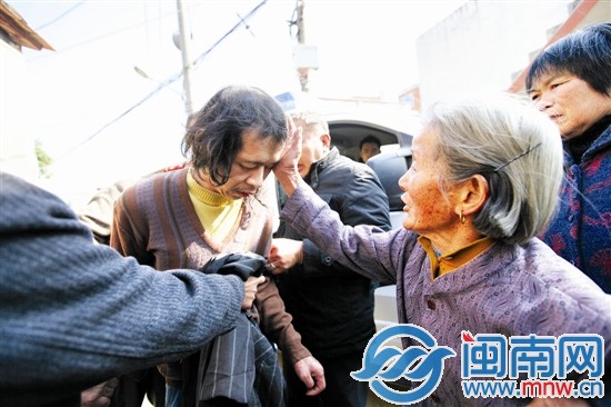 上车前，母亲肖红婴不舍，带着老茧的手不住地摸阿海 