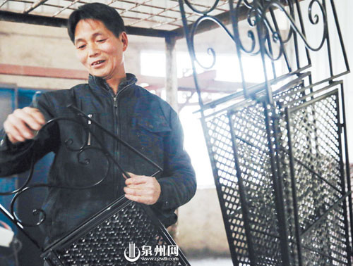 村民将烘干油漆的藤铁工艺品收起入库，这样的折叠铁 