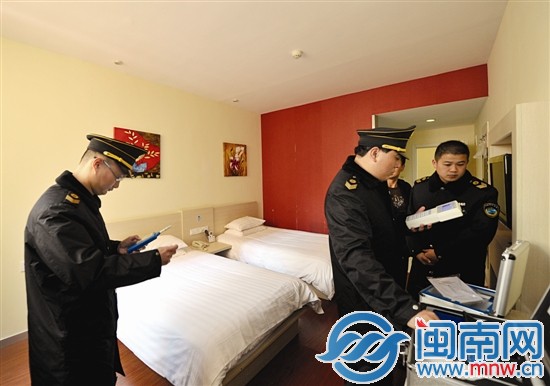 执法人员测量快捷酒店房间内PM10数值